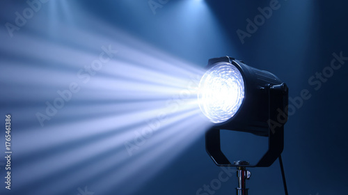 Spotlight illuminating a dark stage with beams of light creating dramatic atmosphere, enhancing visual storytelling in performance art and theatrical presentations