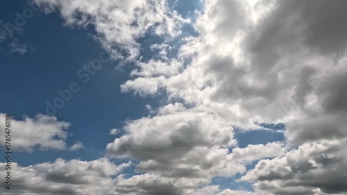 Fantastic Endless Clouds in the Daylight Skies. 4K video (Ultra High Definition) of cloudscape and bright sun. Sky and clouds Timelapse. Sun shines through the clouds on the blue sky background.