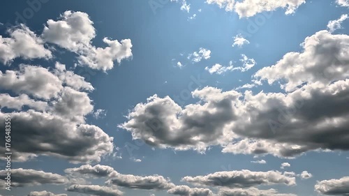 Flowing rainy clouds in the blue skies. 4K video (Ultra High Definition) of cloudscape. Sky and clouds Timelapse. Sun shines through the dramatic clouds on the blue sky background.