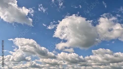 Great endless clouds in the blue skies. 4K video (Ultra High Definition) of cloudscape. Sky and clouds Timelapse. Sun shines through the clouds on the blue sky background.
