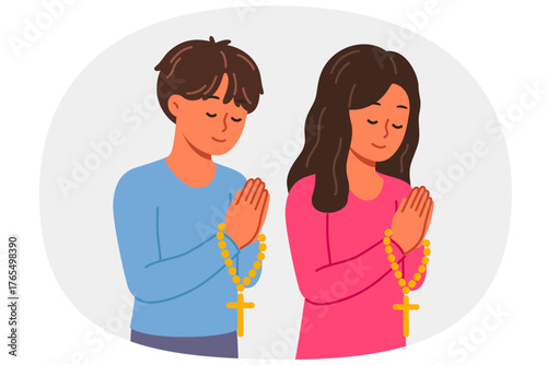 Christian children pray holding rosary with religious crosses and turning to god. Christian boy and girl from elementary school, demonstrating peace and humility before lord from bible
