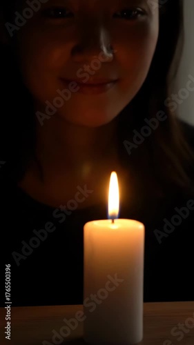 Soft warm candle flame glows gently in dark with peaceful calm light creating intimate and soft glow atmosphere for relaxation and calm moments