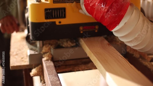 A man is using a woodworking machine to cut a piece of wood