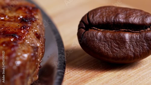 A close-up features a single, roasted coffee bean and the edge of a cooked meat, both on wood