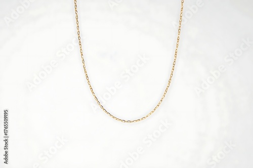 Delicate gold chain necklace with small scattered beads on a white background