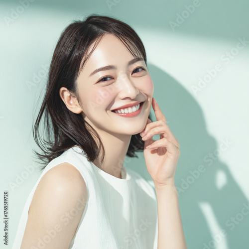 笑顔できらめく綺麗な肌と白い歯を見せる日本人女性美人モデルの写真。オーラルケア、スキンケア、コスメ広告用。