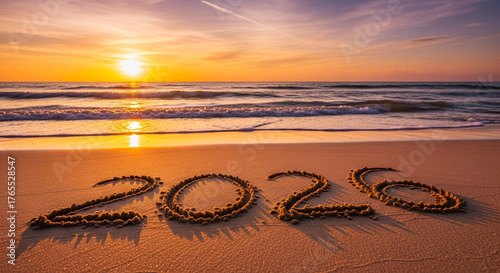 2026 written on beach sand at beautiful sunset ocean horizon