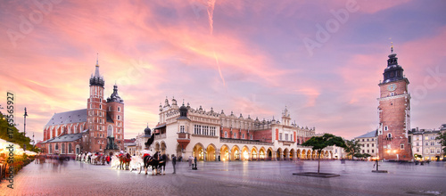 Panorama of St Mary's Basilica (Mariacki Church) and The Main Market and tower in the Old Town of Krakow, Poland illuminated at sunset