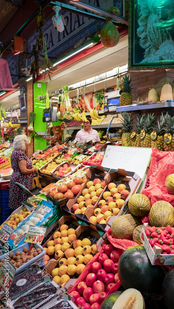 Fototapeta premium Indoor fruit and vegetable stall at the Andalusian market located at the entrance in the historic district across the Guadalquivir River in Mercado de Triana, Seville, Andalusia, Spain