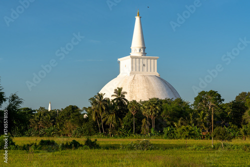 Foto White stupa rises above lush green tropical landscape