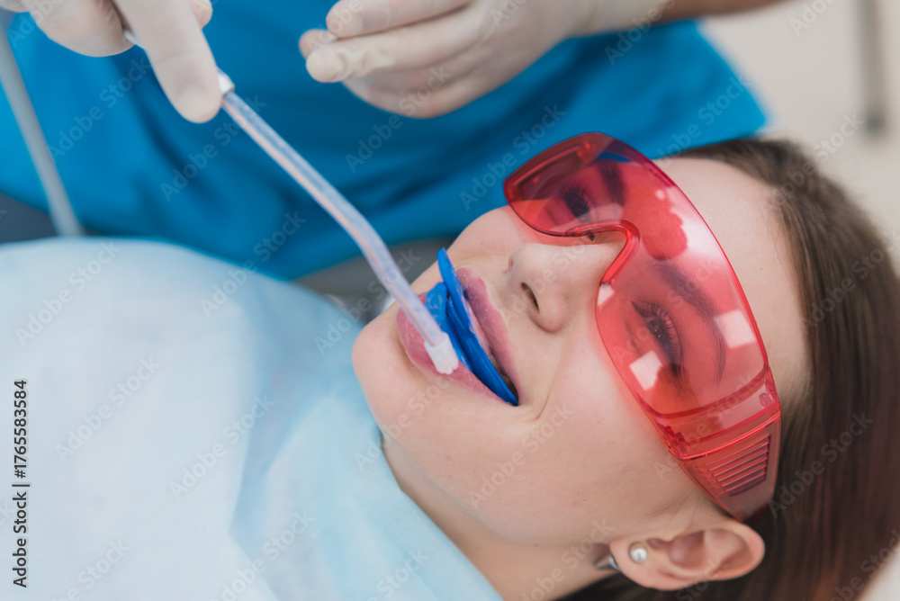 Naklejka premium doctor orthodontist performs a procedure for cleaning teeth