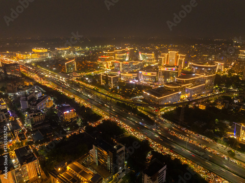 Wallpaper Mural Aerial view of a glittering cityscape with brightly lit buildings and highways teeming with streaks of light, illuminating the urban nightscape, Gurugram, Haryana, India. Torontodigital.ca