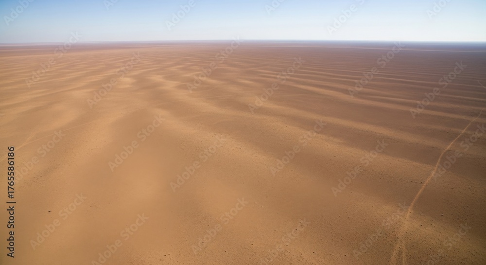 Naklejka premium Expansive desert landscape with rippled sand patterns under clear sky