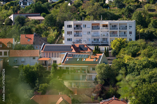 Fototapeta Solar panel rooftops in green hillside neighborhood