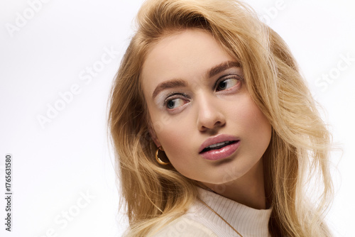 Canvastavla Beautiful young blonde woman in cozy knit outfit on a wintery backdrop