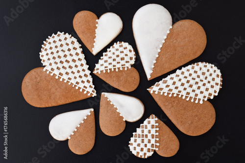 Decorated heart-shaped gingerbread cookies on a black background