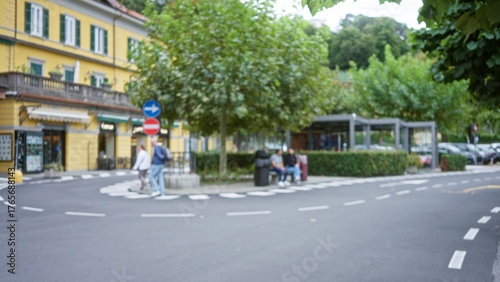 Wallpaper Mural City street captured in soft bokeh with defocused storefronts, trees, hedges, parked cars and crosswalk markings, street; background backplate copyspace calm. Torontodigital.ca