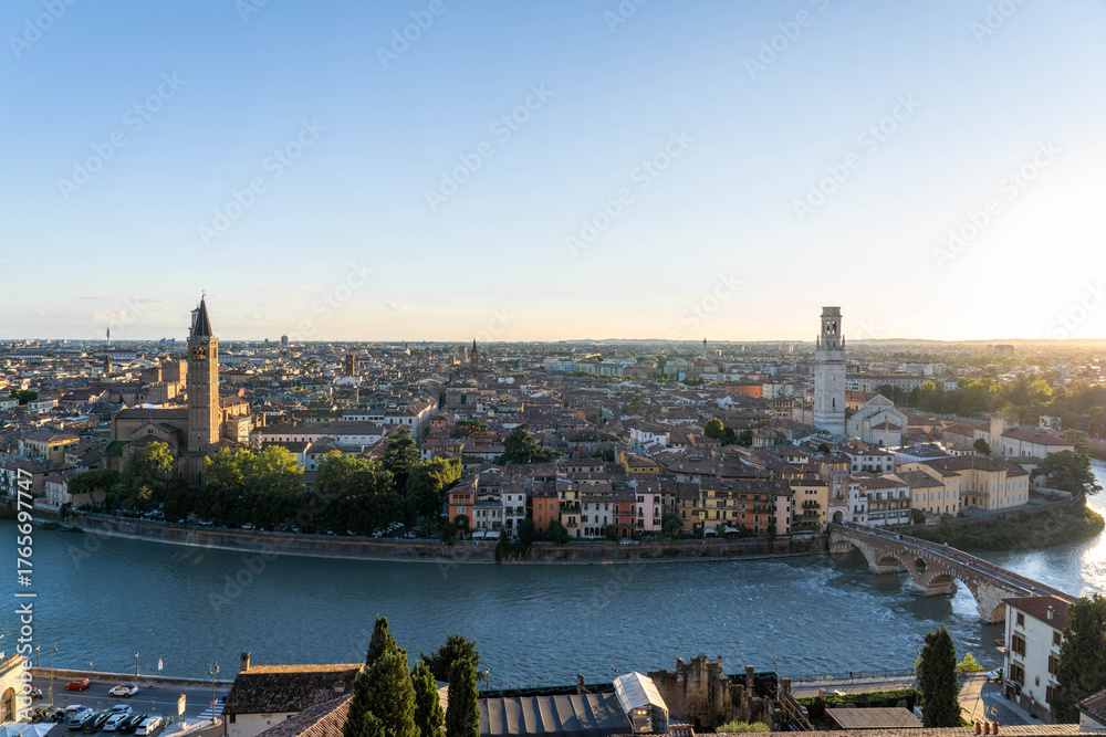 Obraz premium Historic District of Verona Italy with Church Towers as the Sun Sets and Blazes Across the Sky