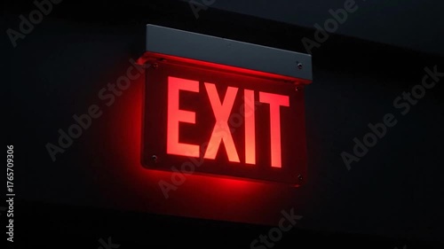 Illuminated red EXIT sign glowing against a dark background, providing guidance in a dark setting