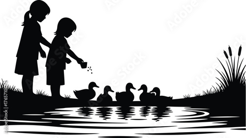 Two young children silhouetted feeding ducks by a peaceful pond at sunset with reeds