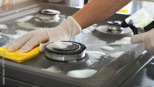 Woman of cleaning cooker indoors at home