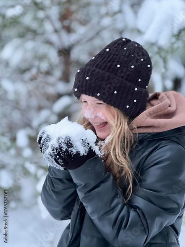 a teenage girl enjoys the snow, plays and has fun. winter holidays
