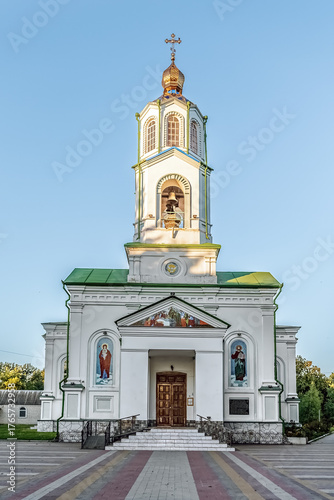 Beautiful Assumption Cathedral in Myrhorod with golden dome, bell tower, and Orthodox icons on white facade in Poltava region. Myrhorod, Ukraine - June 29, 2024