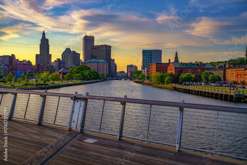 View of downtown Providence and the Providence River at colorful sunset, seen from a pedestrian footbridge in Rhode Island, USA.