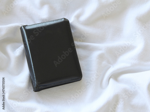 Overhead view of black mockup friendly leather book cover with space for text overlay on a white surface with copy space. 