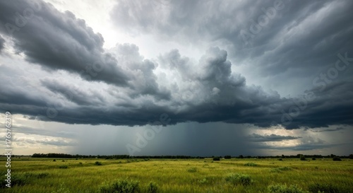 Massive storm clouds gather over a grassy plain