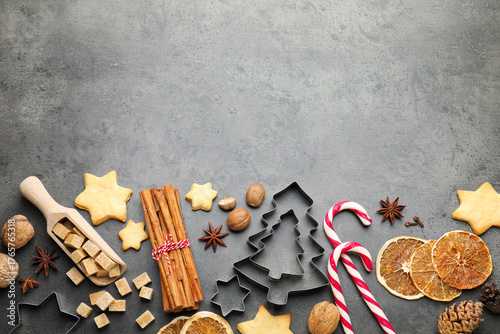 Fototapeta Naklejka Na Ścianę i Meble -  Christmas composition with cookies, cutters and spices on grey table, flat lay. Space for text