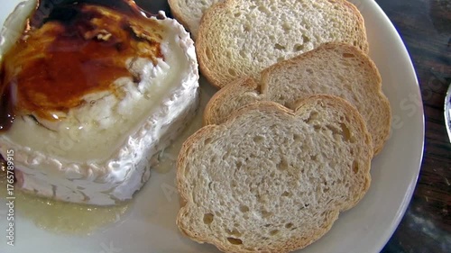 Soft cheese dish with honey and croutons on the table.
Queso de Cabra con Miel in an Andalusian restaurant.
