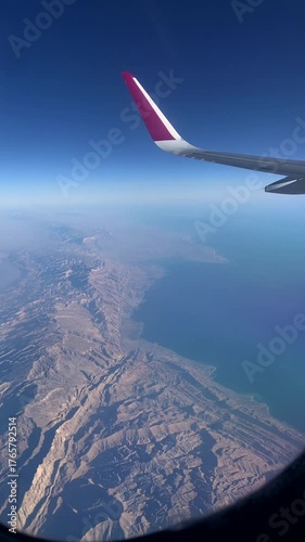 Mountains seen from an airplane window. Airplane wing seen from an airplane window.
