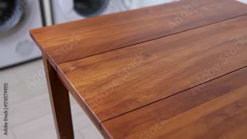 Close up of a wooden table in front of washing machines.