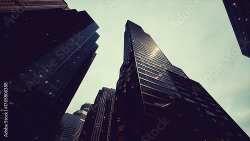 Fotografie Tall buildings rise dramatically toward the clouds, showcasing sleek glass exteriors