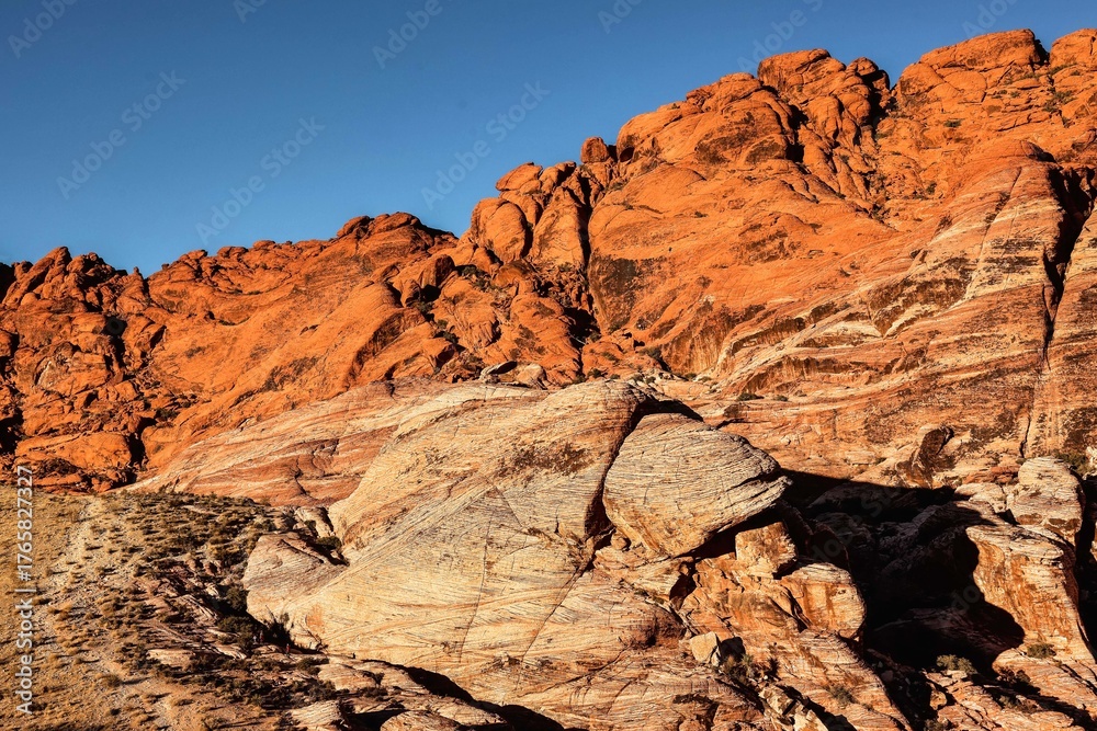 Fototapeta premium Vibrant Red Sandstone Peaks Rise Majestically Against Azure Skies in Red Rock Canyon's Ancient Desert Embrace, Nevada