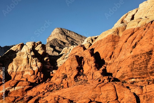 Vibrant Red Sandstone Peaks Rise Majestically Against Azure Skies in Red Rock Canyon's Ancient Desert Embrace, Nevada