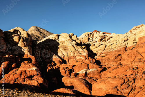 Vibrant Red Sandstone Peaks Rise Majestically Against Azure Skies in Red Rock Canyon's Ancient Desert Embrace, Nevada