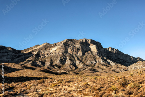 Majestic Crimson Sandstone Spires Pierce Azure Nevada Skies, Unveiling Ancient Desert Layers in Red Rock Canyon's Timeless, Sun-Drenched Embrace