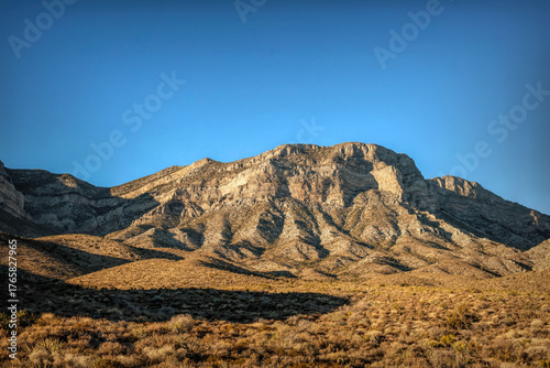 Majestic Crimson Sandstone Spires Pierce Azure Nevada Skies, Unveiling Ancient Desert Layers in Red Rock Canyon's Timeless, Sun-Drenched Embrace