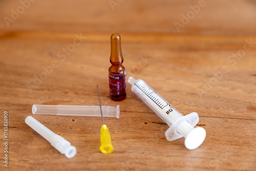 Impfstofffläschchen und Injektionsspritze auf Holztisch