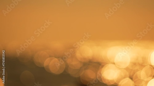 Sunlight bokeh water shimmering golden ocean surface abstract summer background.