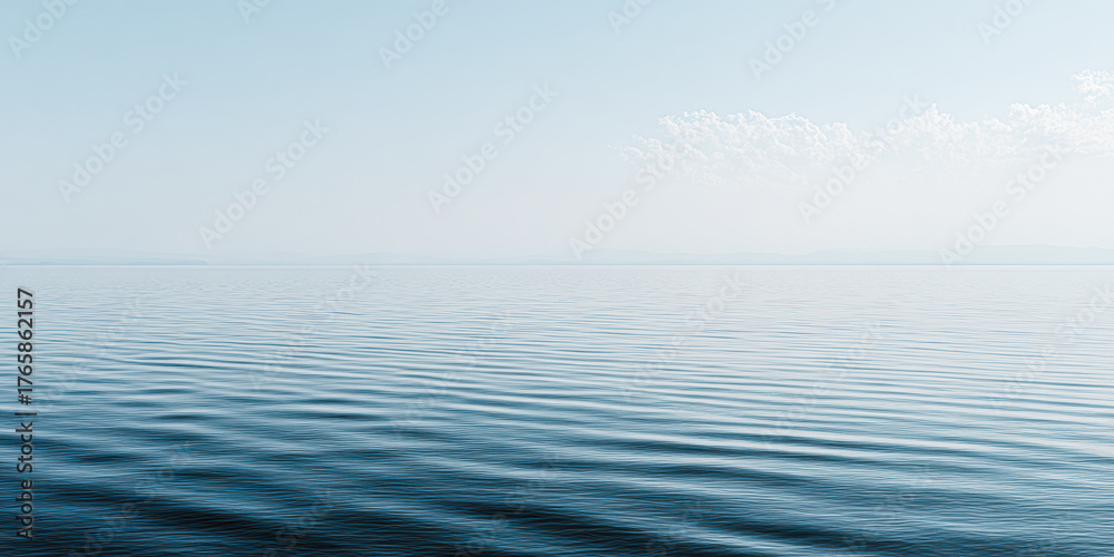 Obraz premium A serene seascape featuring calm waters reflecting a light blue sky with soft clouds, creating a tranquil and peaceful atmosphere.