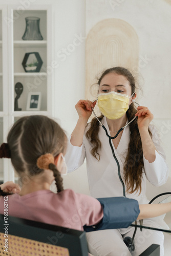 Teenage girl is listening to doctor during medical examination in modern clinic. Concept of medicine and healthcare. Part of a series. Close up