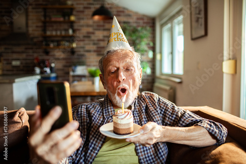 Tableau sur toile Senior man celebrating birthday at home while on a video call