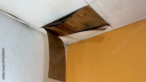 Ceiling damage visible in the corners of the room, revealing rotting wood or plaster peeling from the structure. Home problems include water infiltration and poor maintenance.