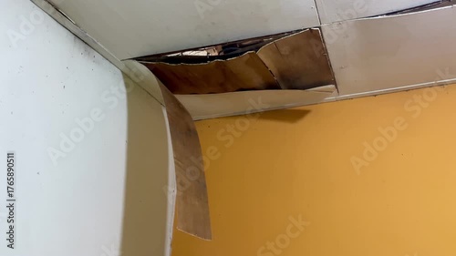 Ceiling damage visible in the corners of the room, revealing rotting wood or plaster peeling from the structure. Home problems include water infiltration and poor maintenance.