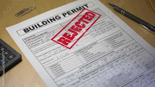 Close-up of a rejected building permit stamped in red ink on a desk with pen and paper clips, symbolizing construction denial or zoning issue. Fictional data. 14916  	