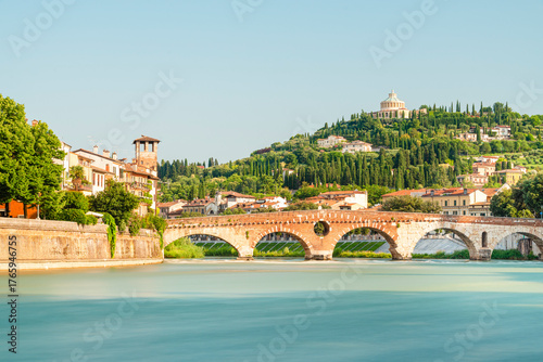 Die römische Ponte Pietra über dem Fluß Etsch in der Altstadt von Verona vor mediterraner Landschaft in der Morgensonne, Venetien, Italien
