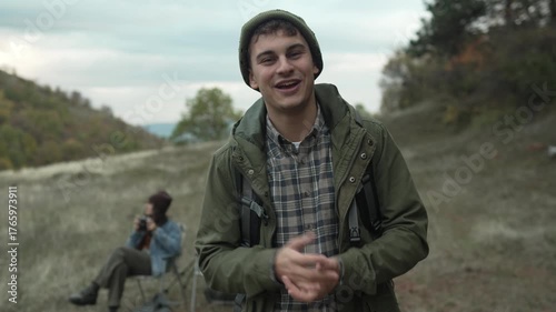 Young male v-logger talking to camera while camping in nature